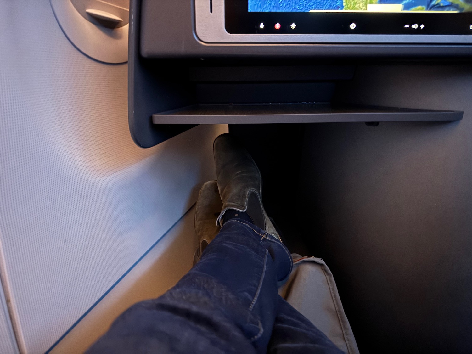 a person's feet in a seat with a tv