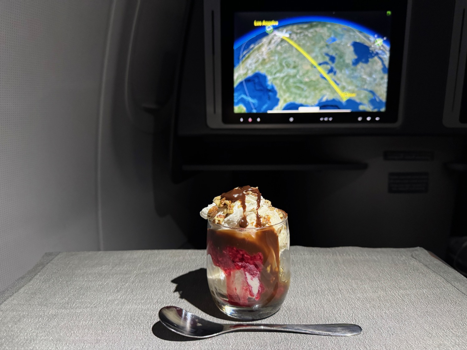 a dessert in a glass with a spoon in front of a television