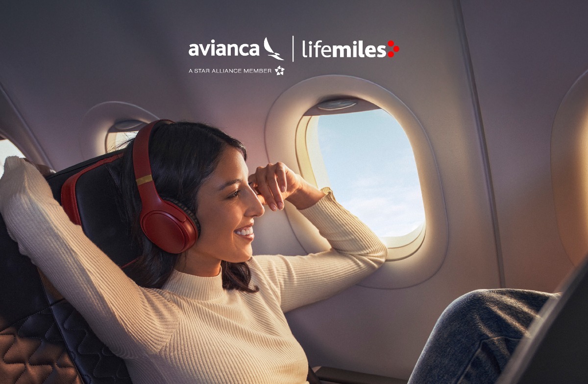 a woman wearing headphones and sitting in an airplane