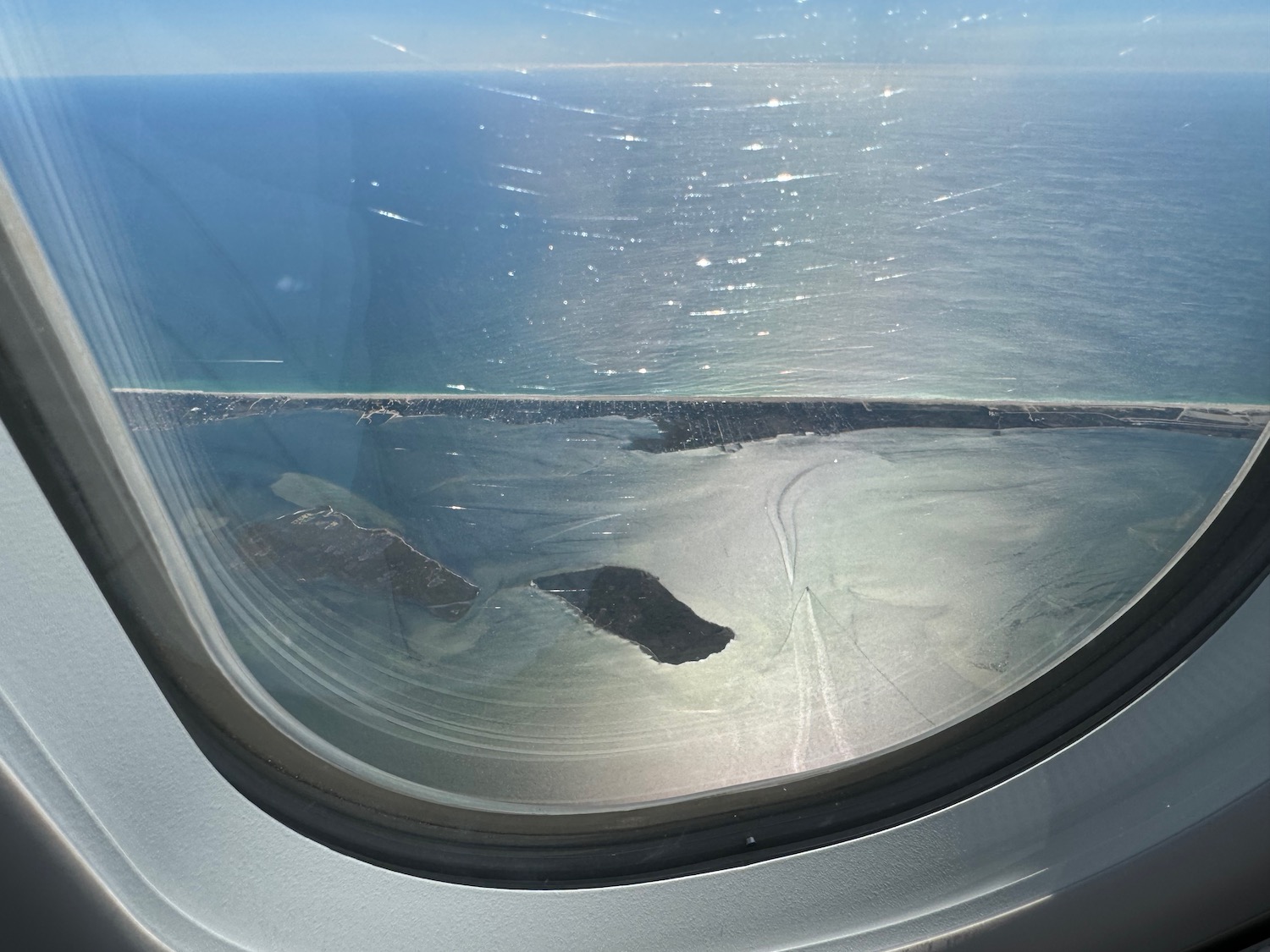 an airplane window with a view of land and water