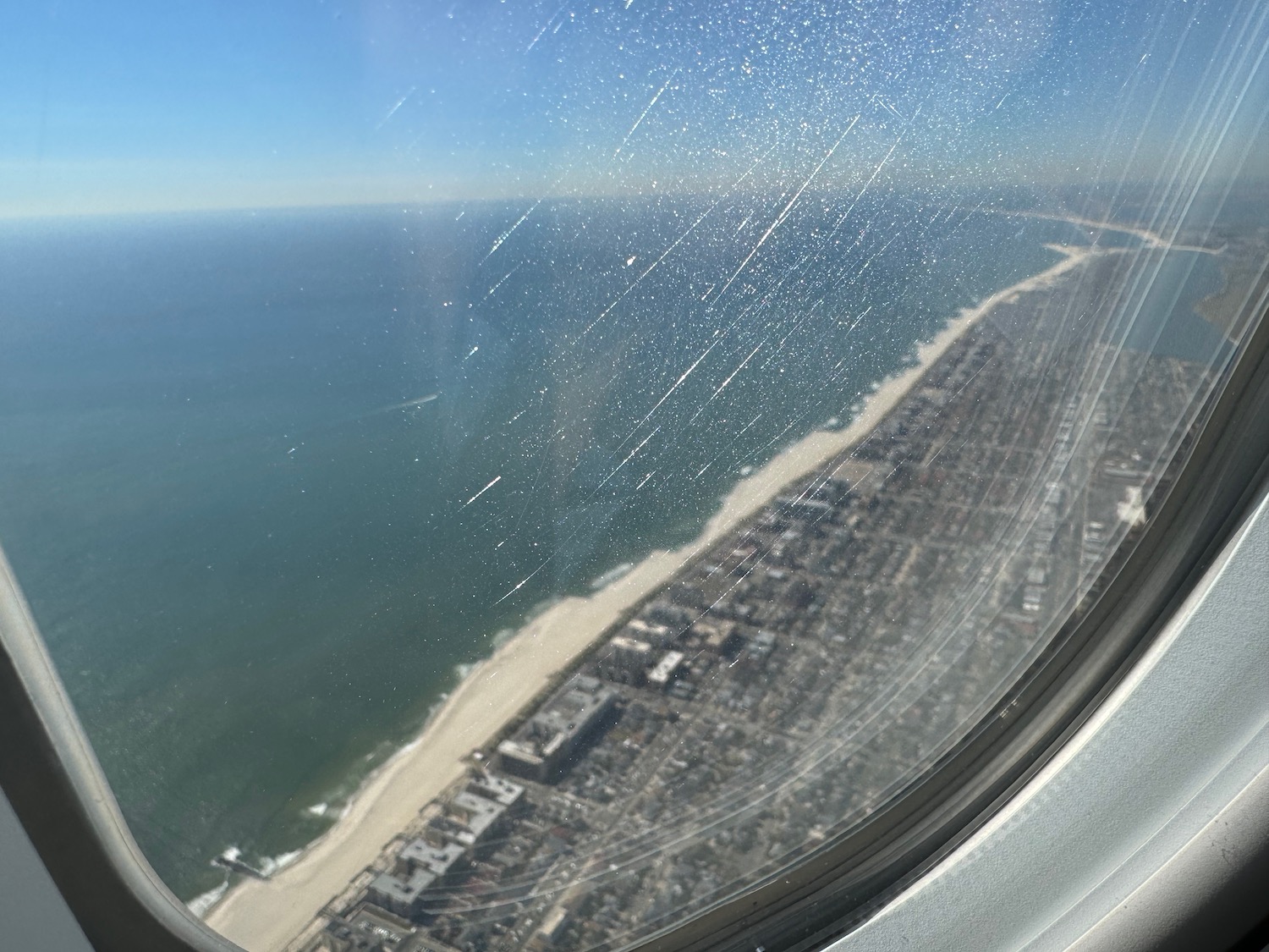 a view of a beach and city from an airplane window