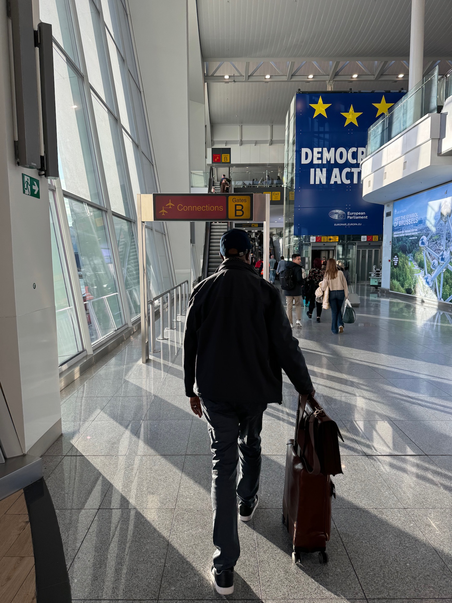 a man walking with luggage in a hallway