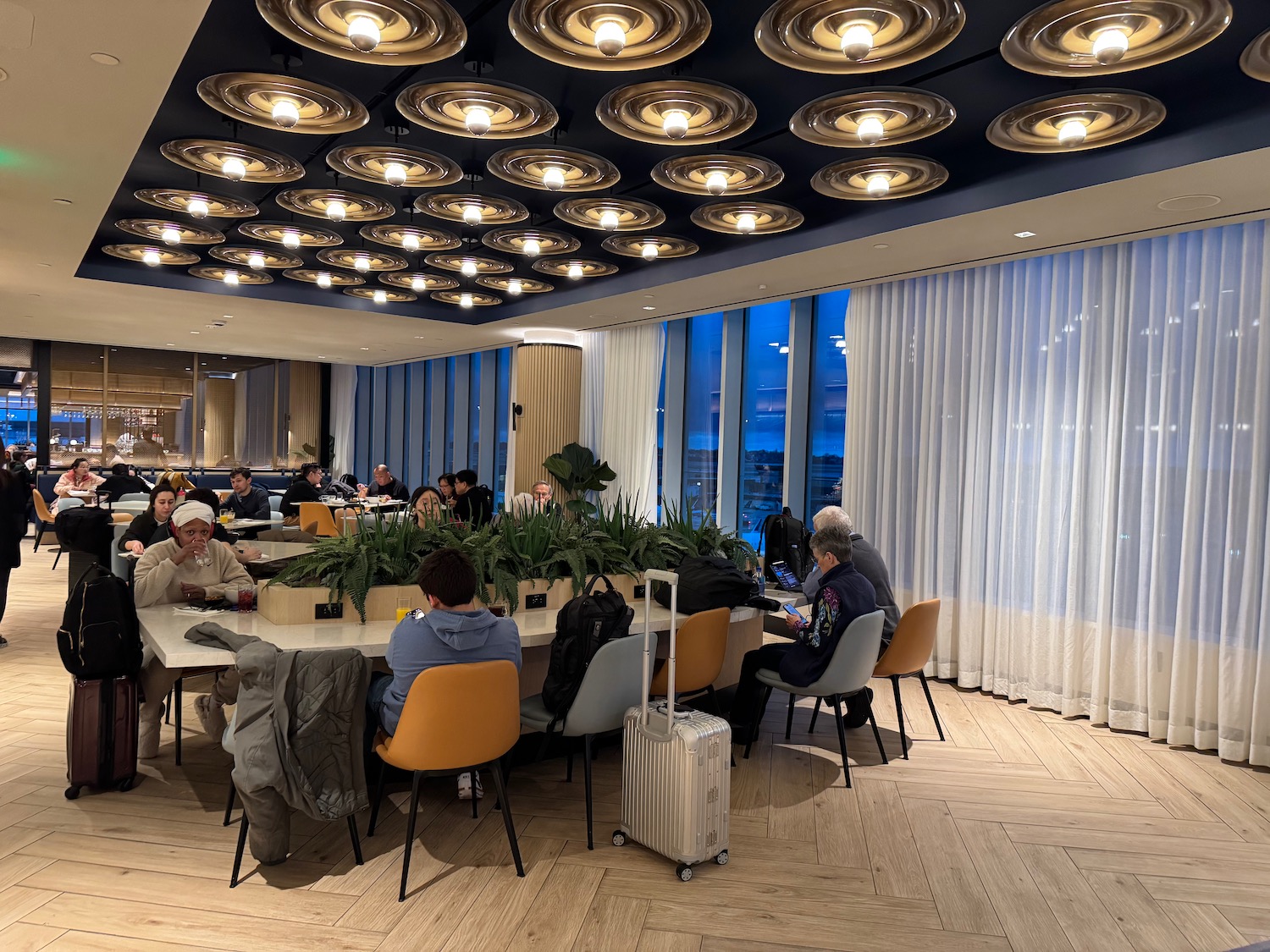 a group of people sitting at a table in a room with lights