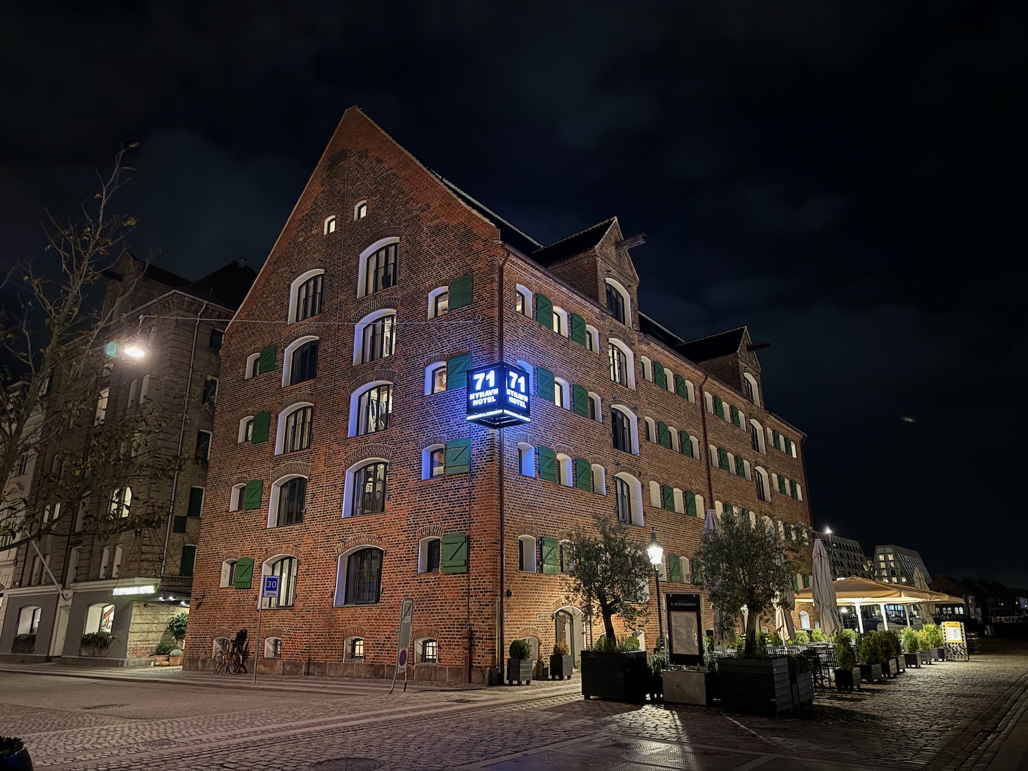 a brick building with green shutters at night