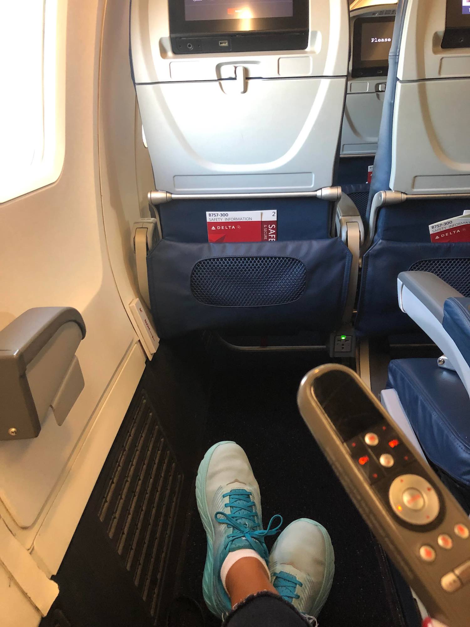 a person's feet in a seat on an airplane