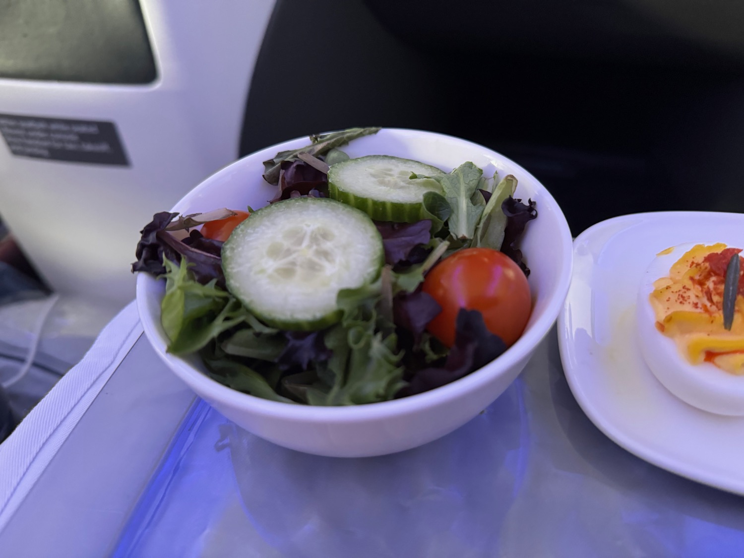 a bowl of salad and egg on a tray