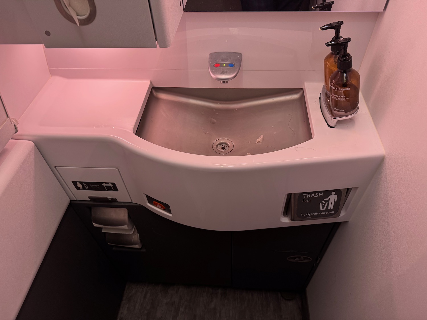 a sink with a soap dispenser and a bottle of liquid