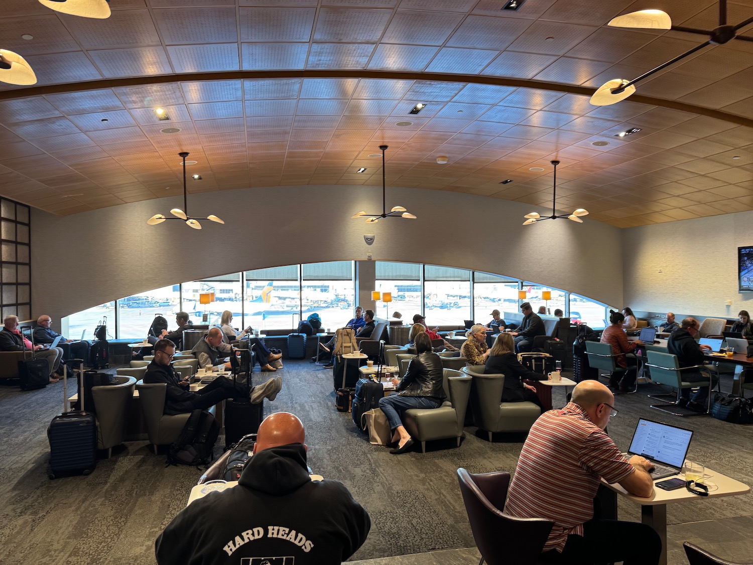 a group of people sitting in a room with tables and chairs