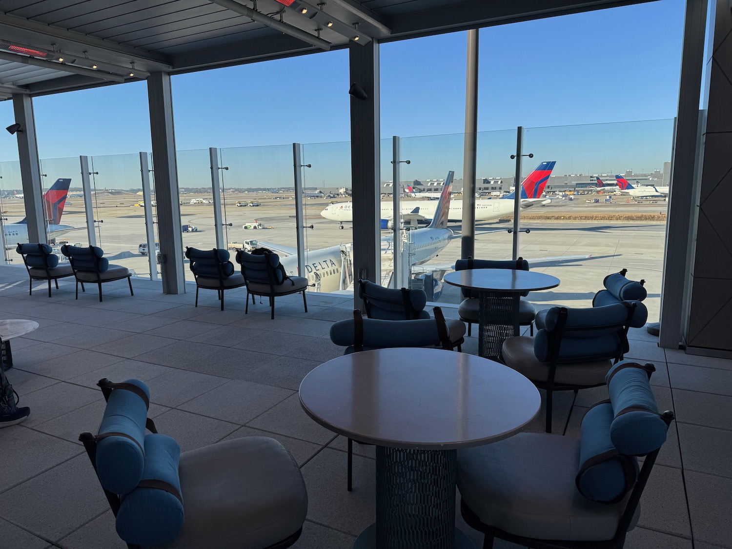 a room with tables and chairs and airplanes in the background