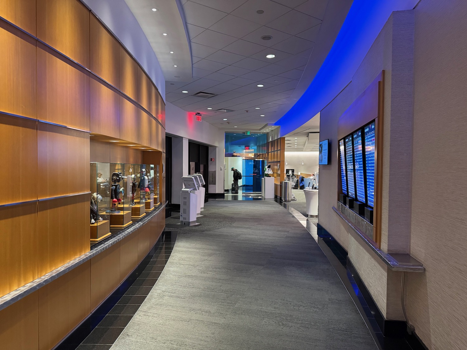 a hallway with display cases and people walking