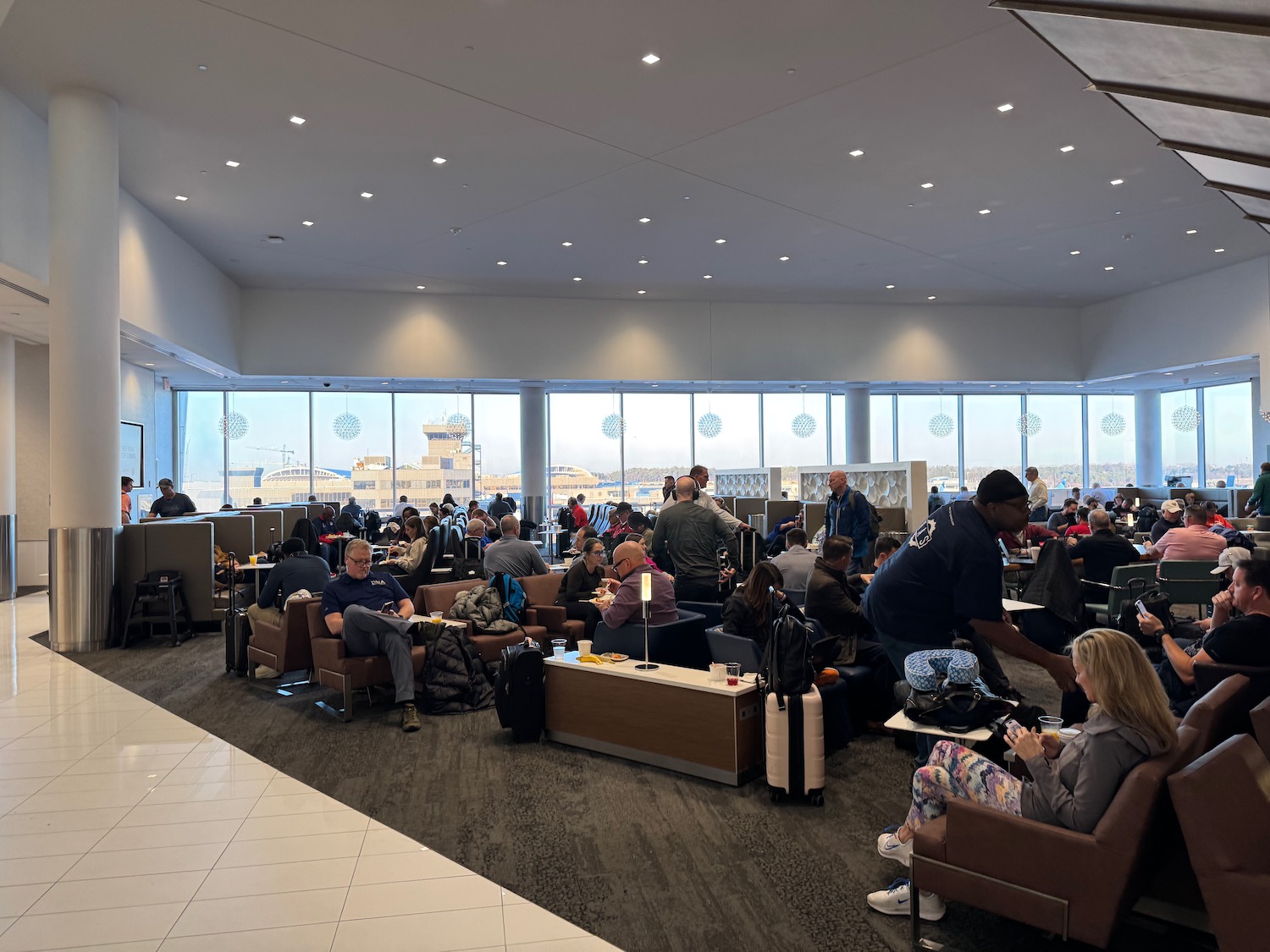 a group of people sitting in a room with large windows