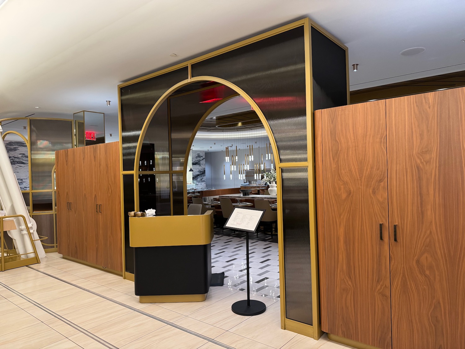 a room with a black and gold arch and wood cabinets