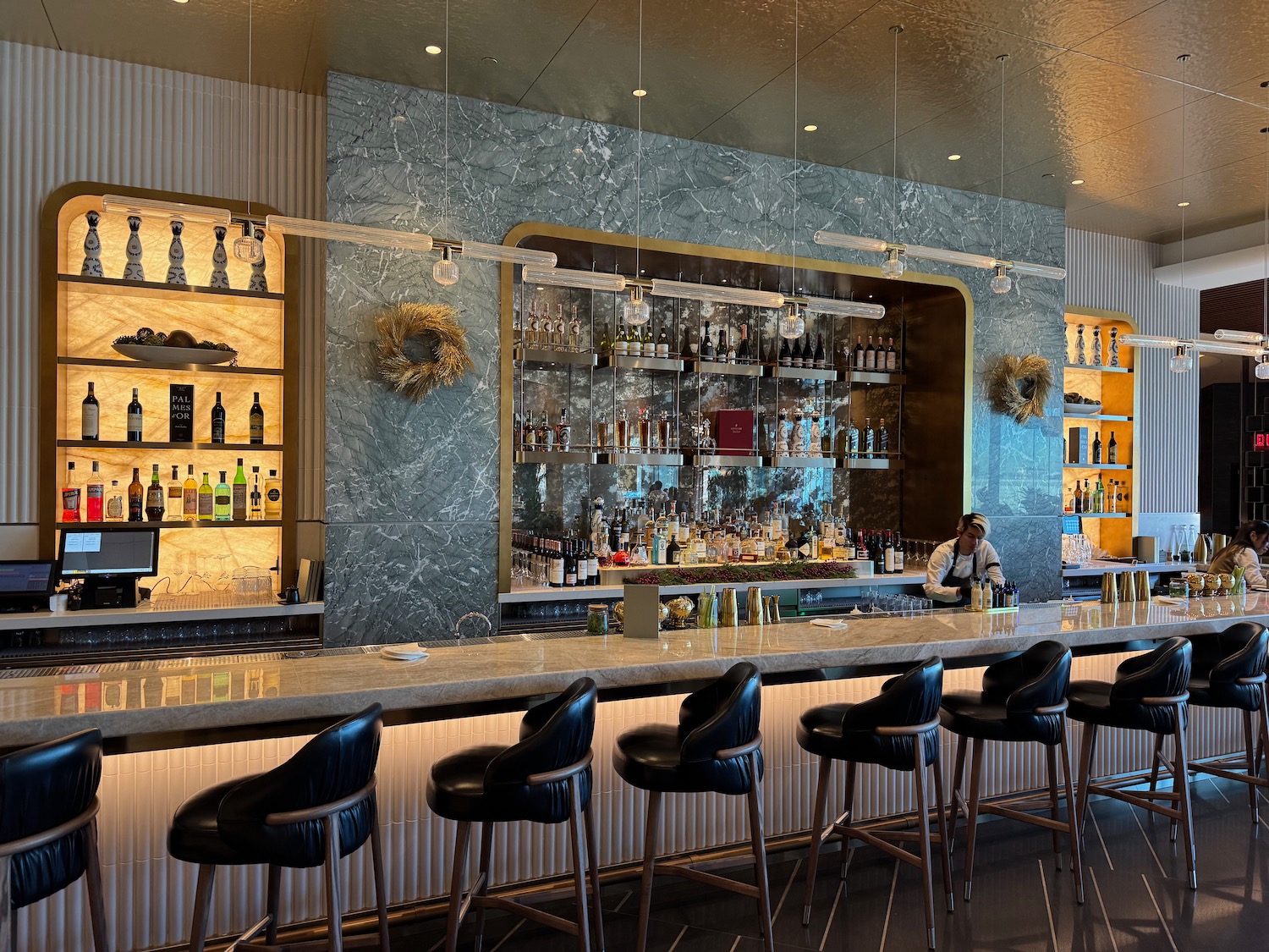 a bar with a counter and a bar with bottles and shelves