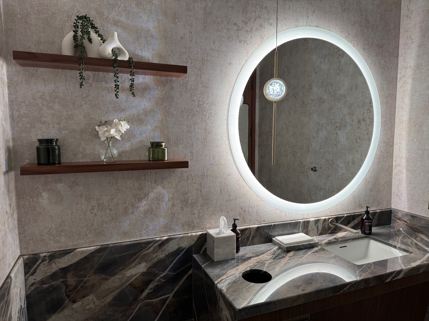 a bathroom with a round mirror and a sink