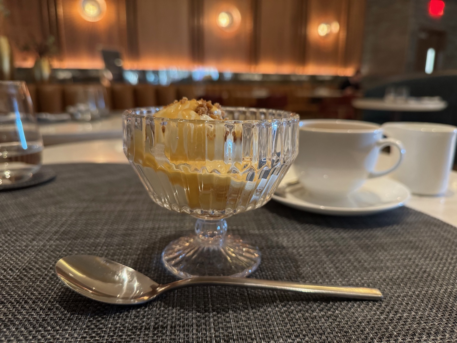 a glass dish with food in it next to a spoon