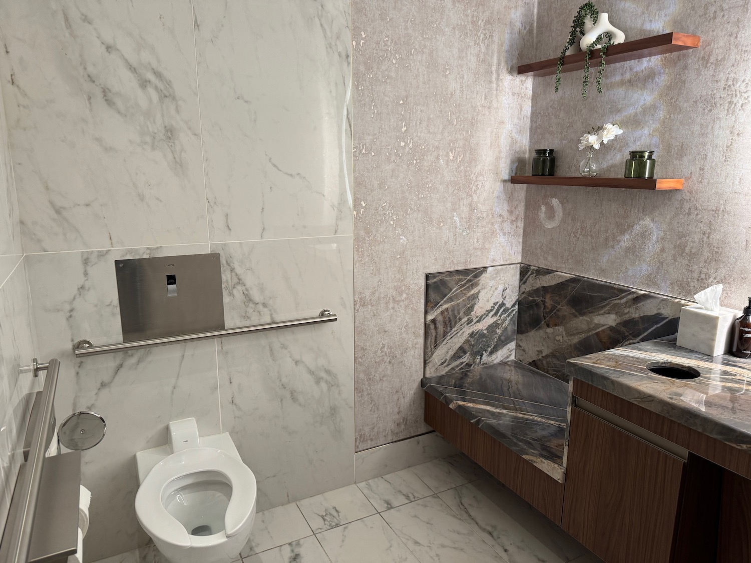 a bathroom with marble walls and a toilet