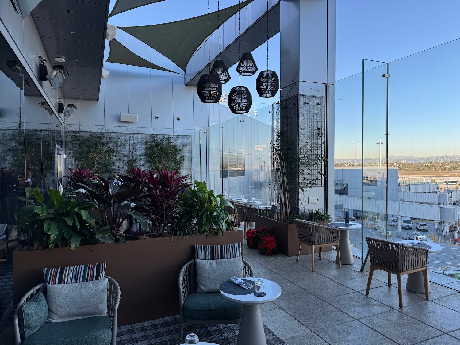 a patio with chairs and tables and plants