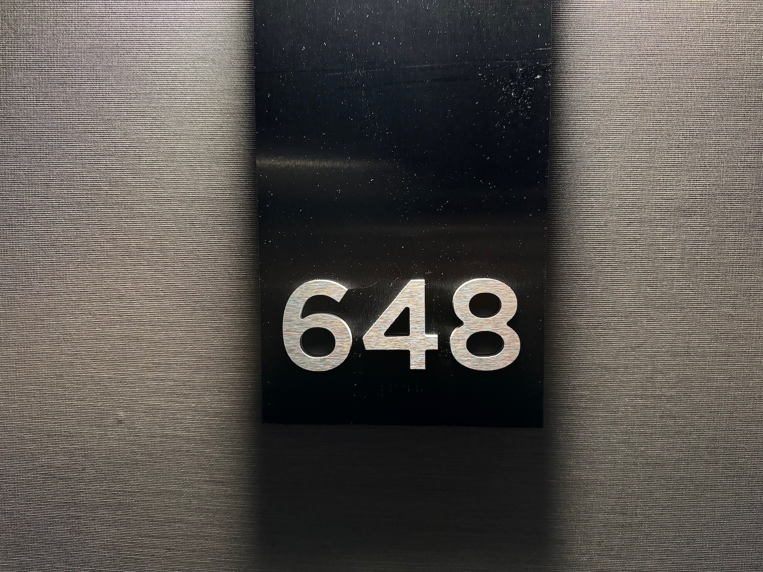 a black rectangular sign with white numbers on it