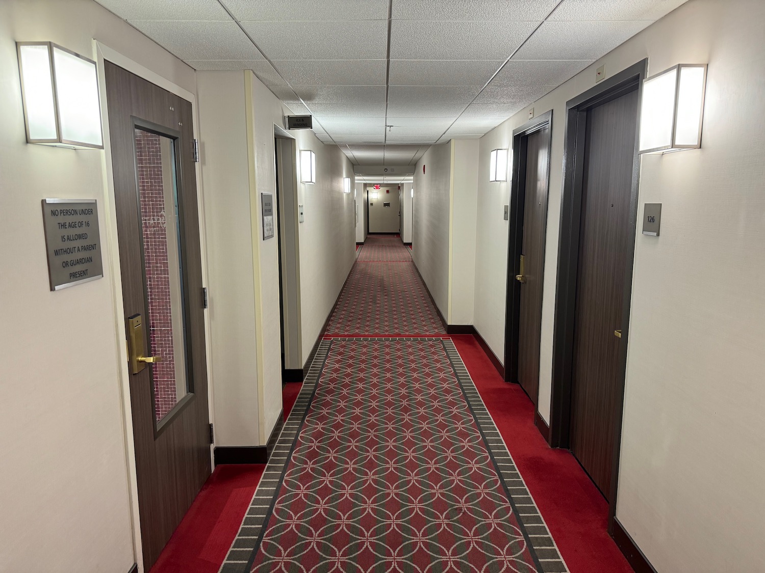 a hallway with doors and red carpet