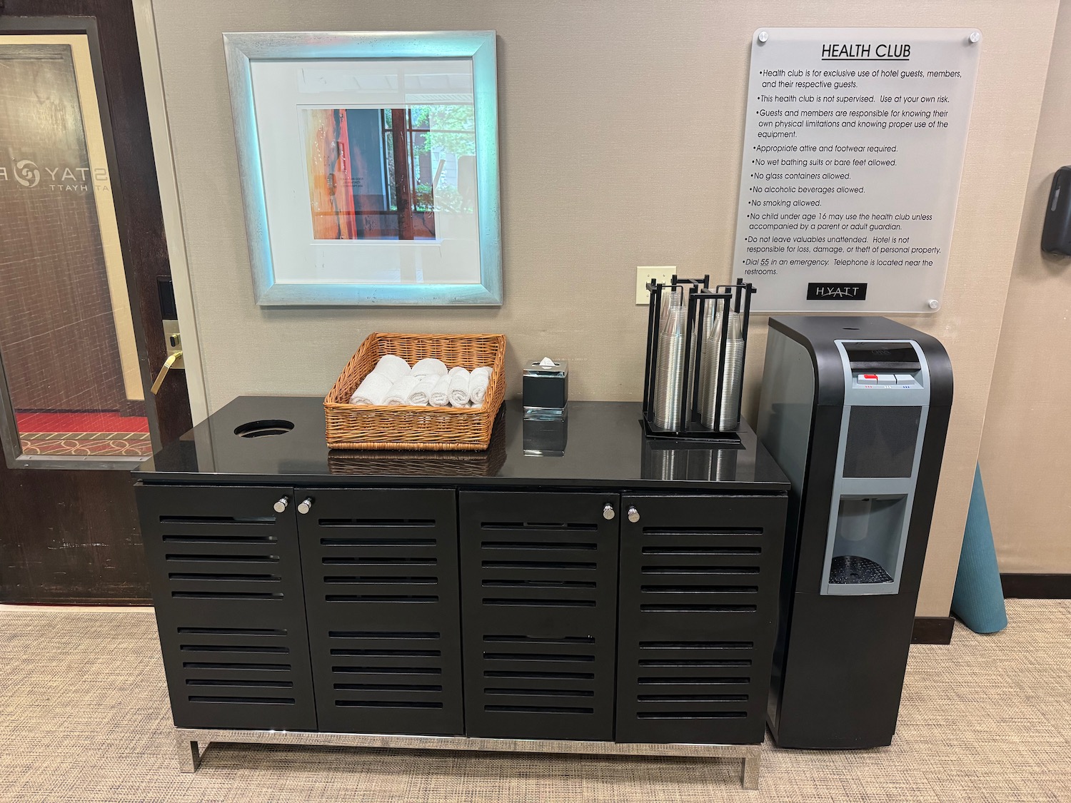 a black cabinet with a basket and a paper towel dispenser