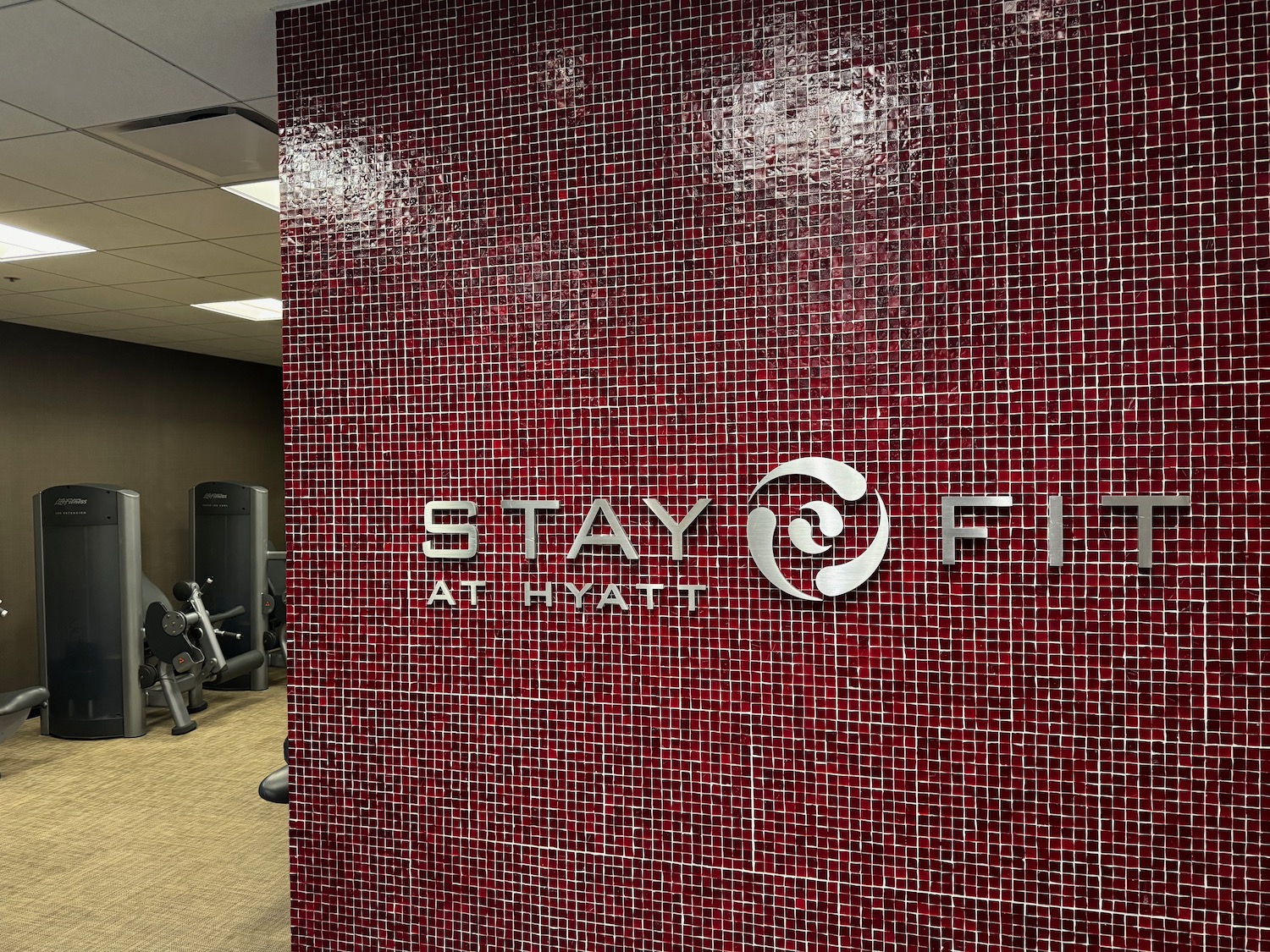 a red tile wall with a logo on it