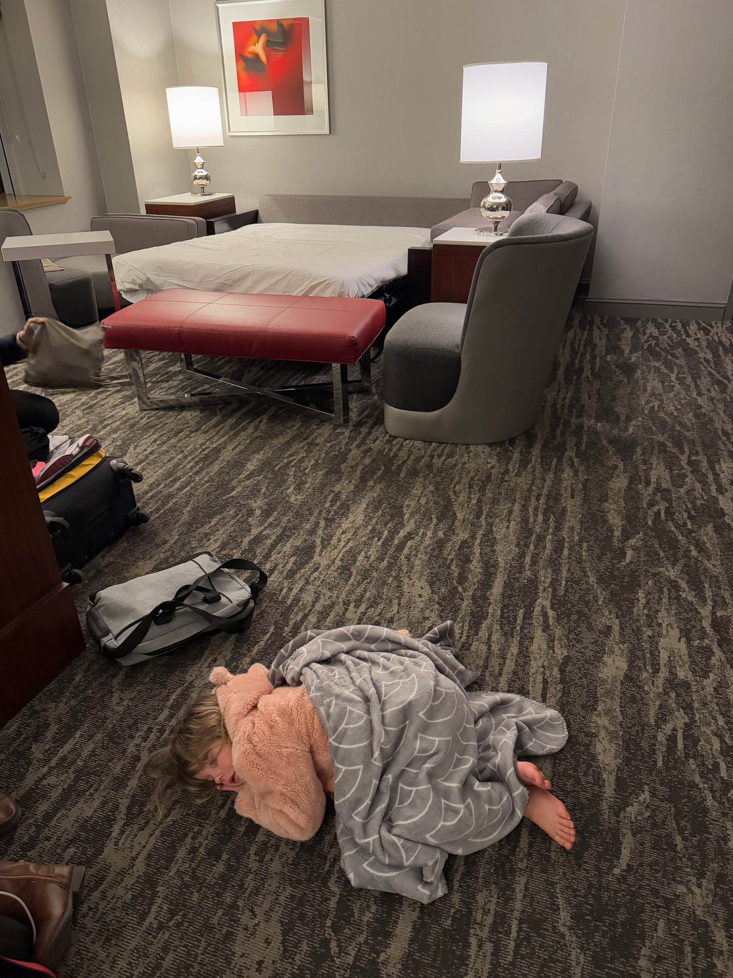 a child sleeping on the floor in a hotel room