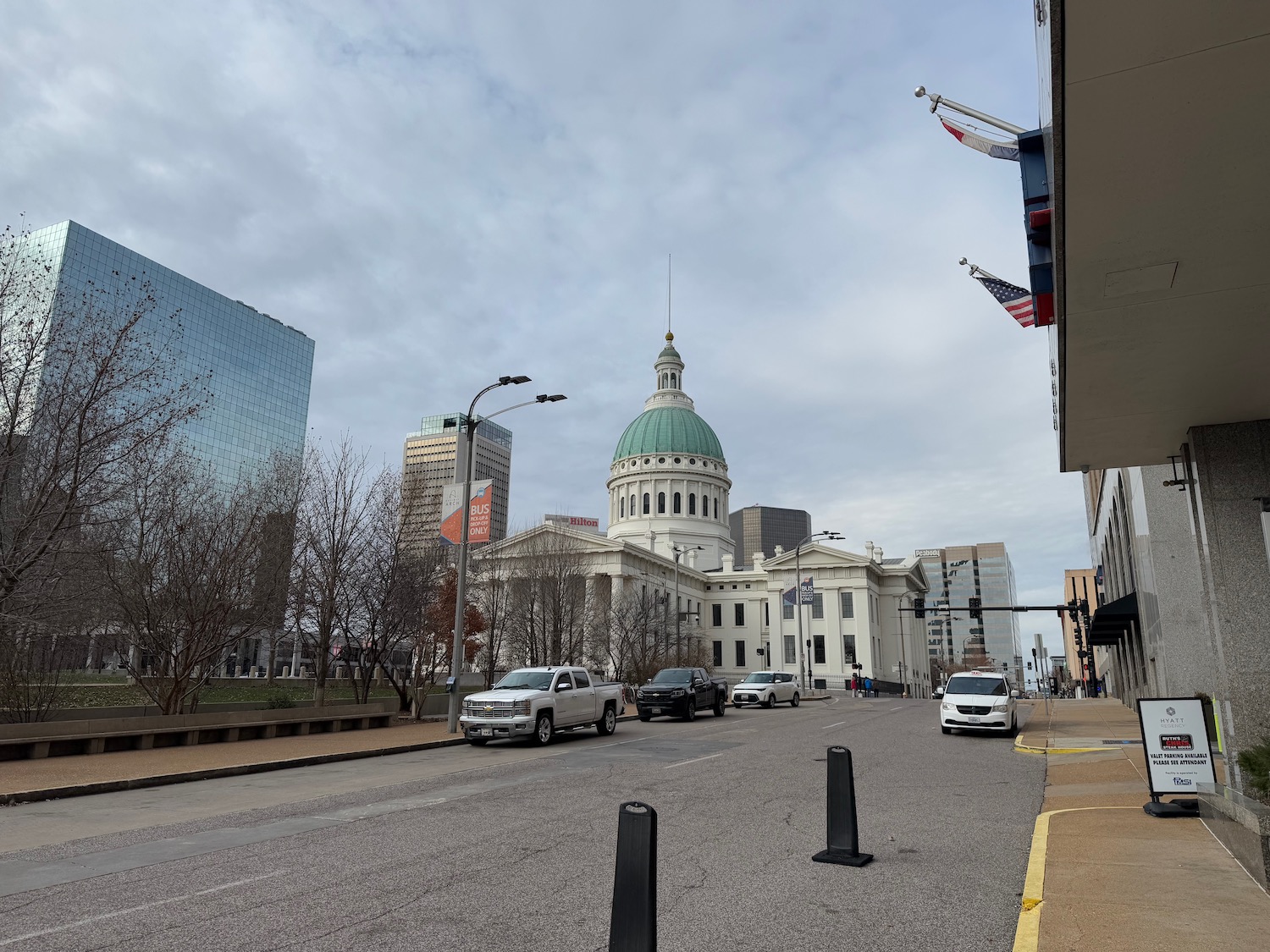 a street with cars and a building with a dome