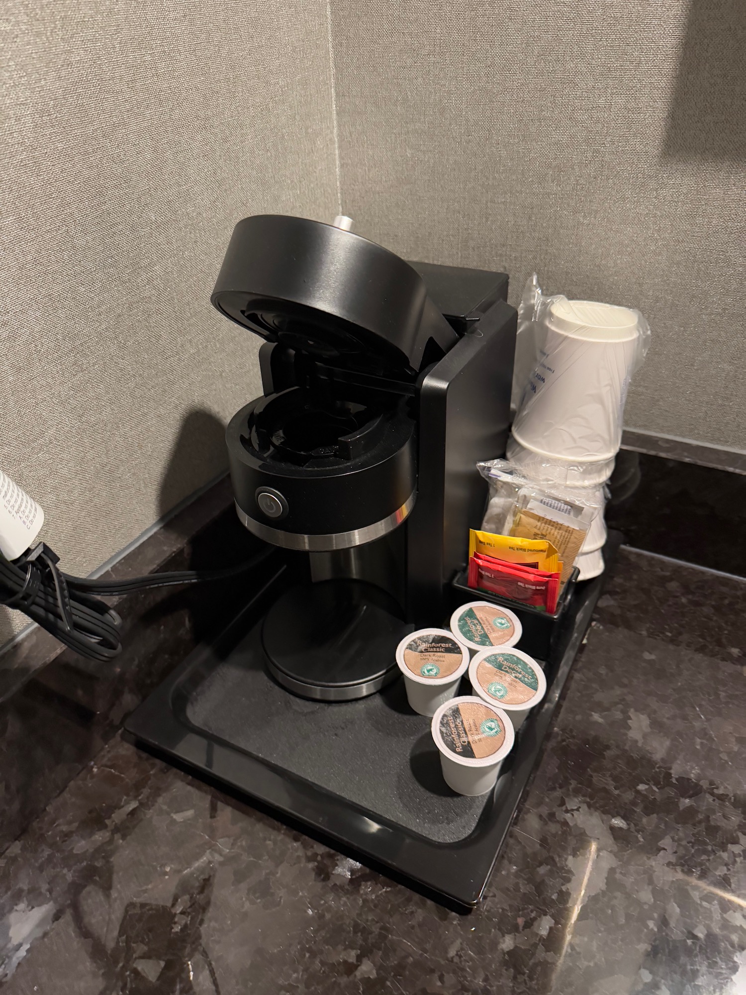 a coffee machine with cups and condiments