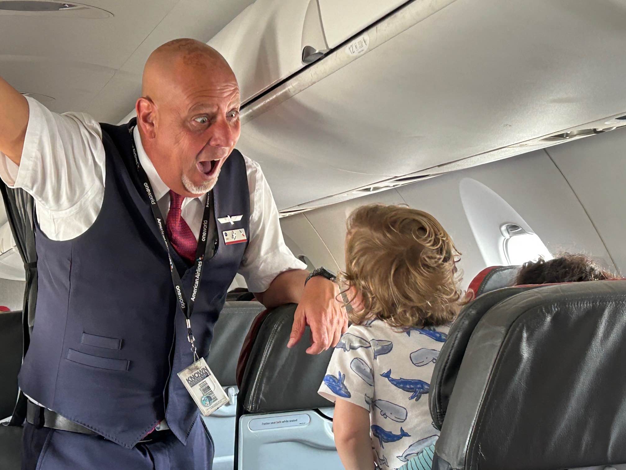 a man in a vest and tie with a child in the back