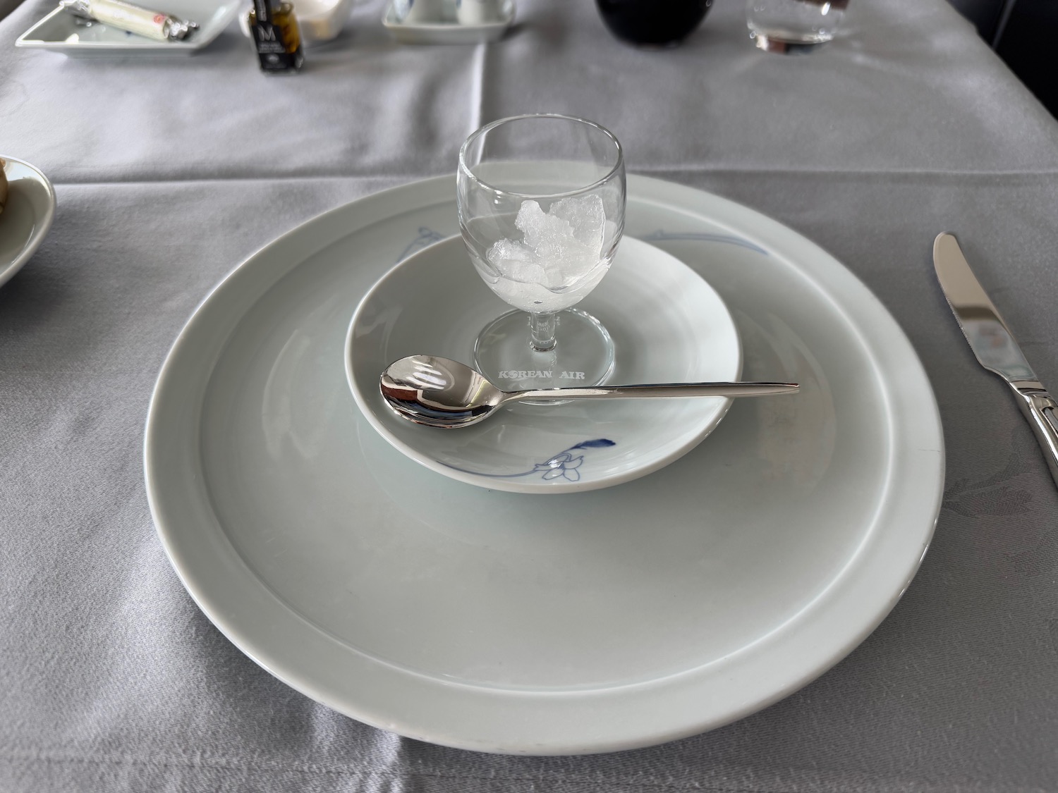 a plate with a spoon and a glass on it