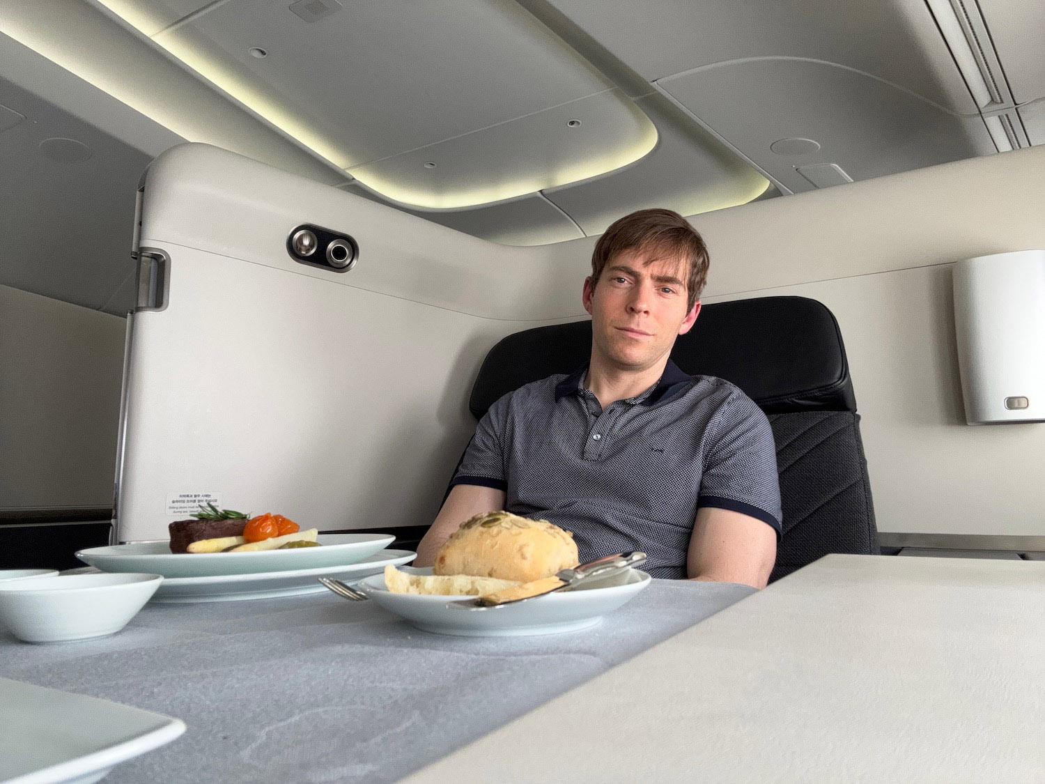 a man sitting in a chair with plates of food on it