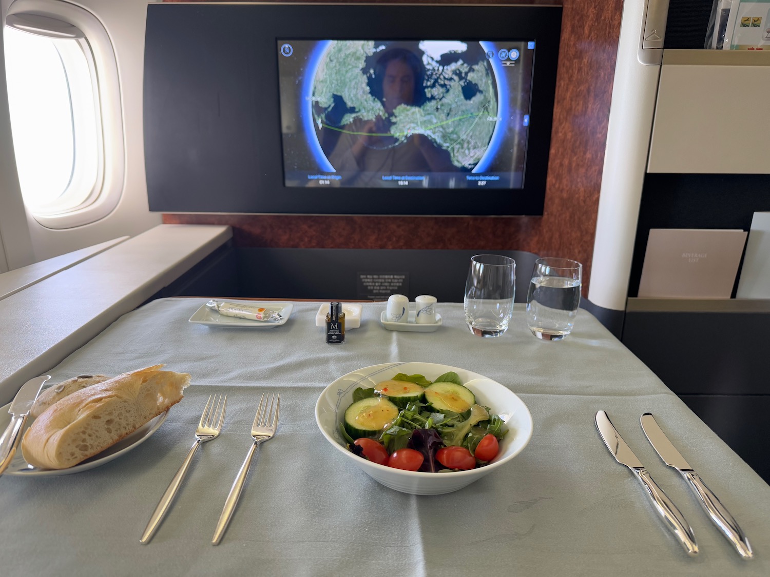 a table with a bowl of salad and a television on the wall