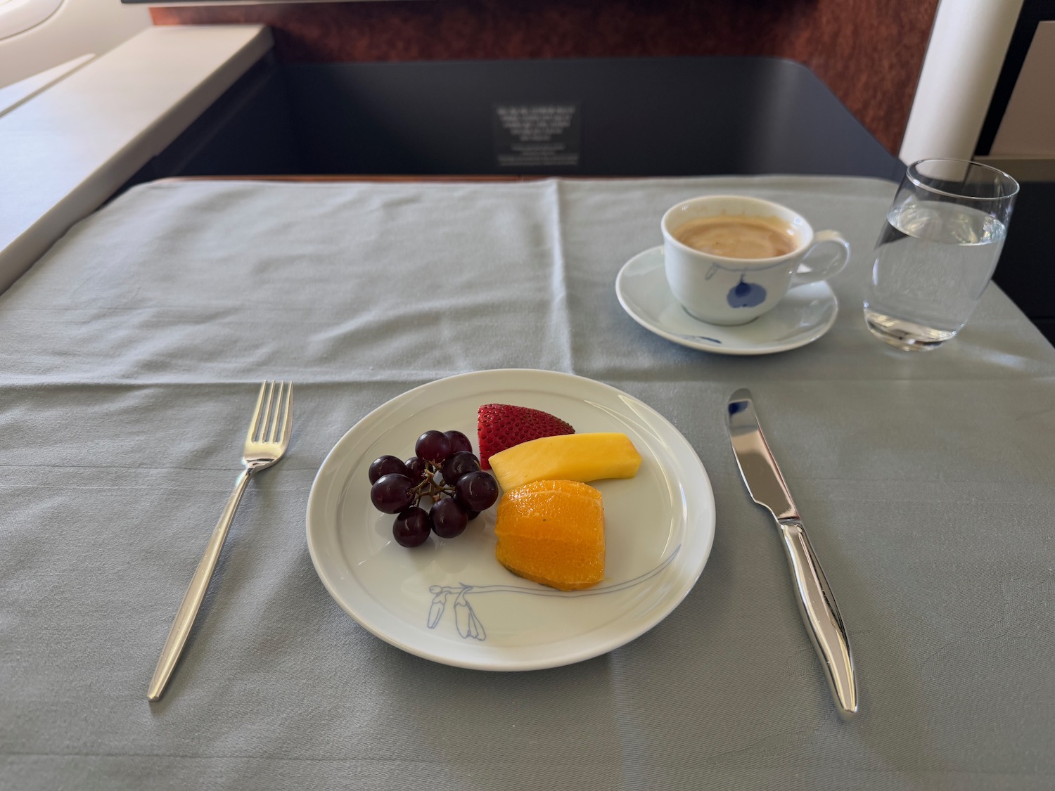 a plate of fruit and a cup of coffee on a table