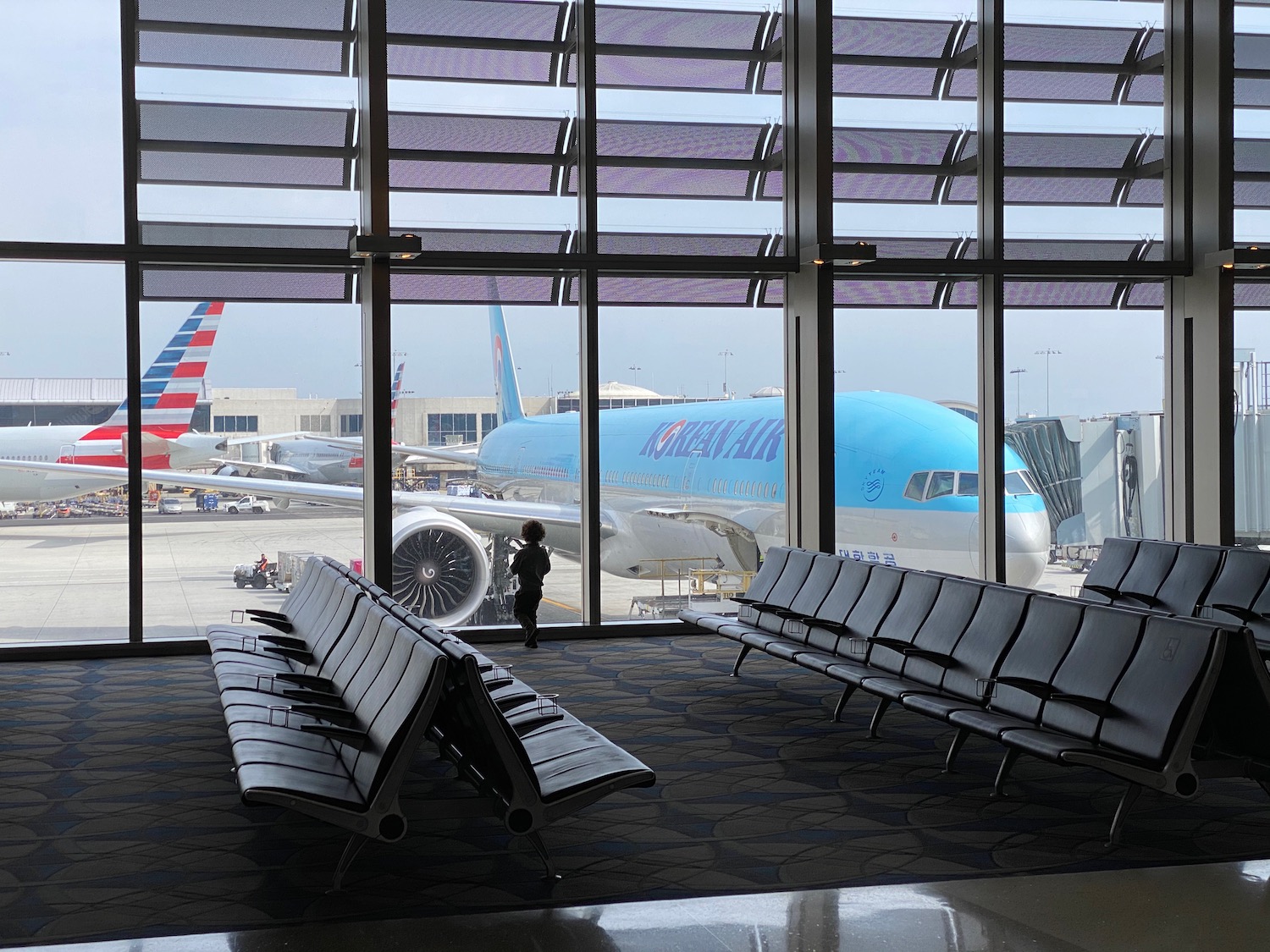 a person standing in a room with seats and a plane in the background