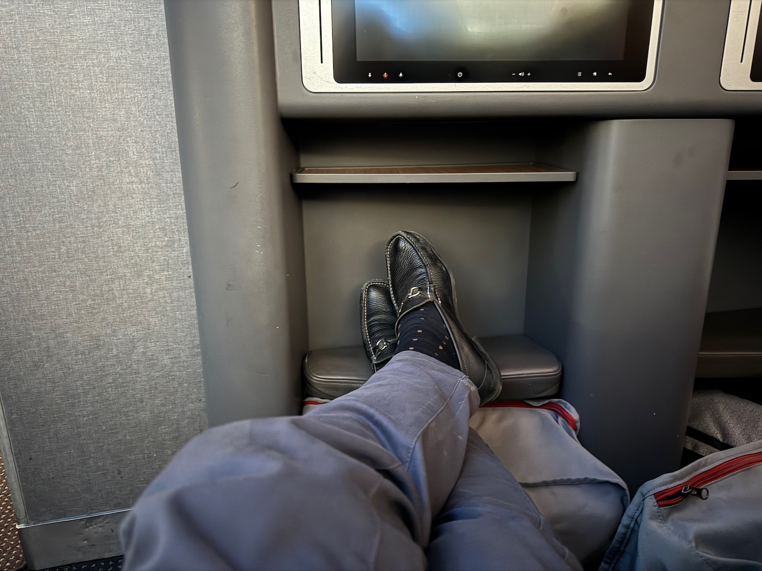 a person's legs in a seat with a tv