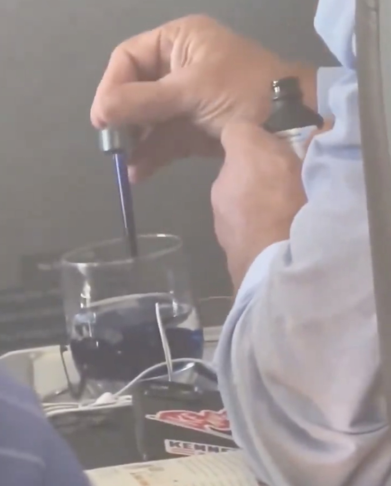 a person using a screwdriver to fill a glass