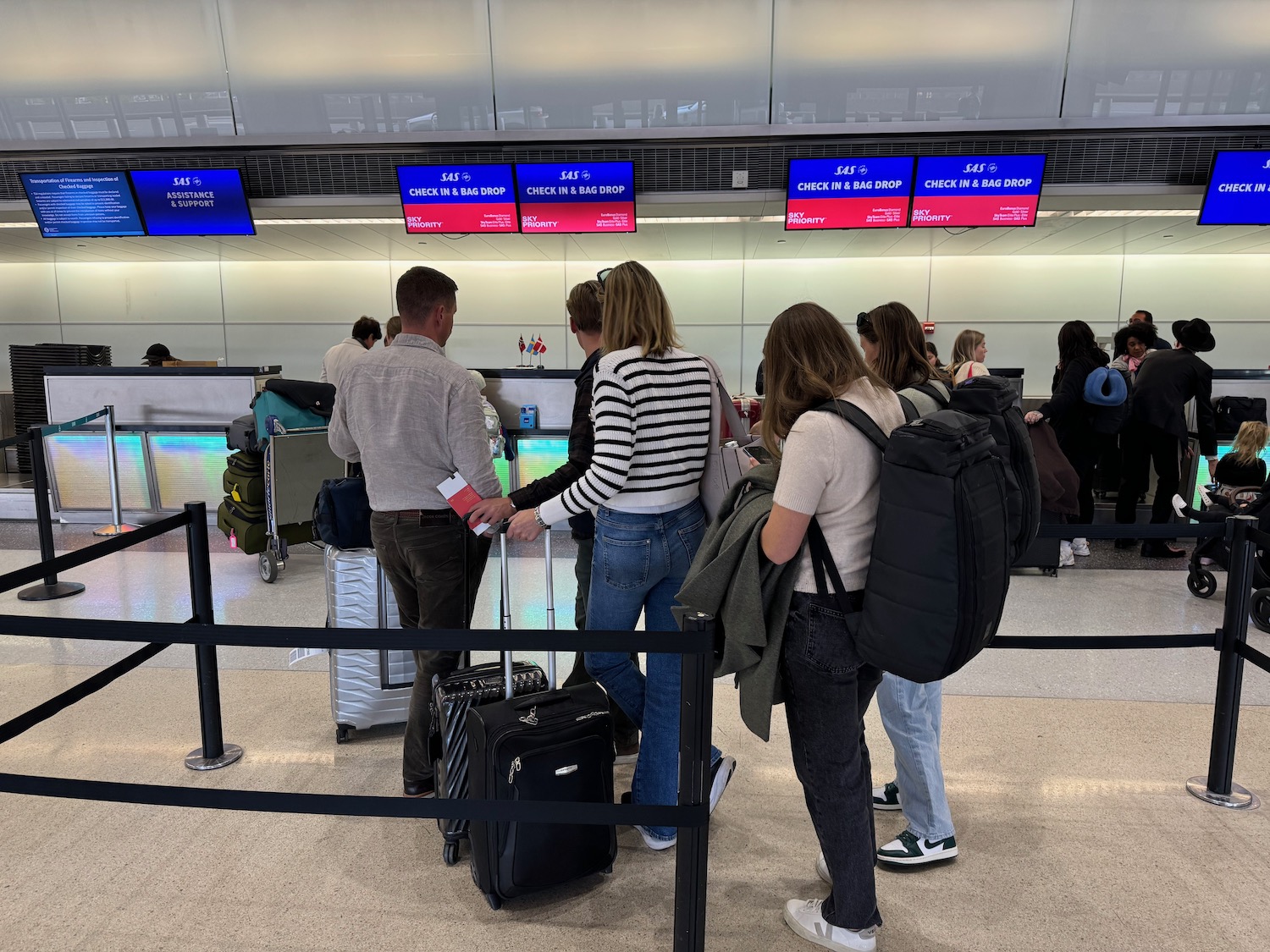 a group of people standing in a line with luggage