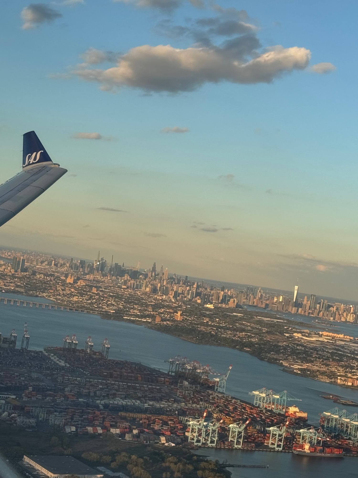 an airplane wing and city view from the window of an airplane