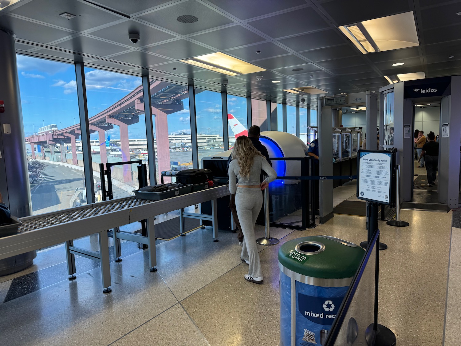 a man and woman standing in a room with a conveyor belt