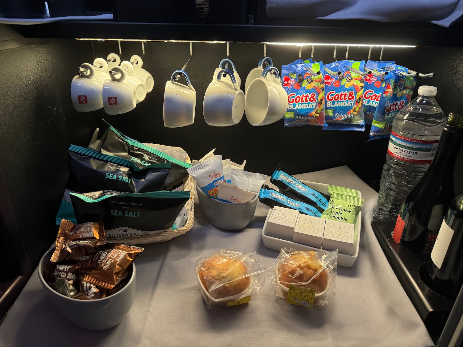 a shelf with coffee cups and snacks