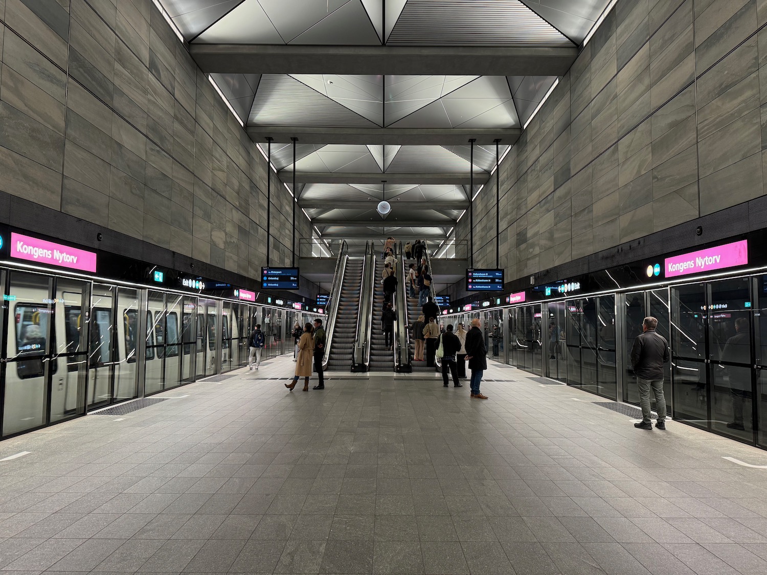 a group of people standing in a subway station