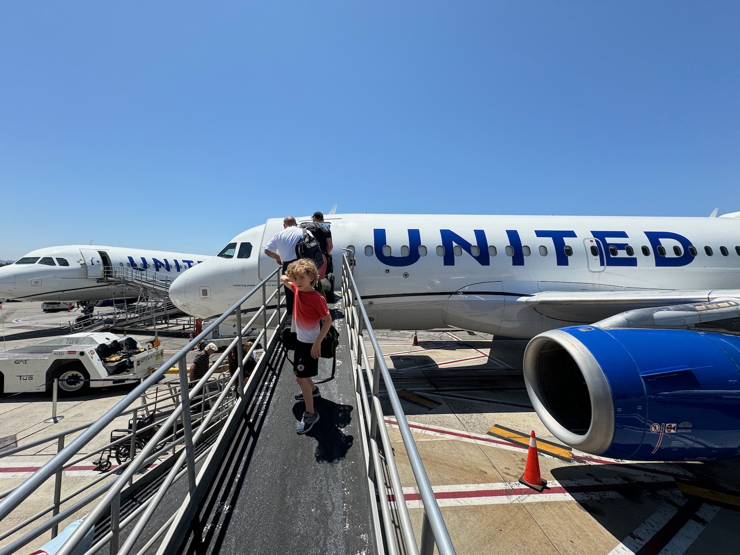 a group of people walking on a ramp next to an airplane