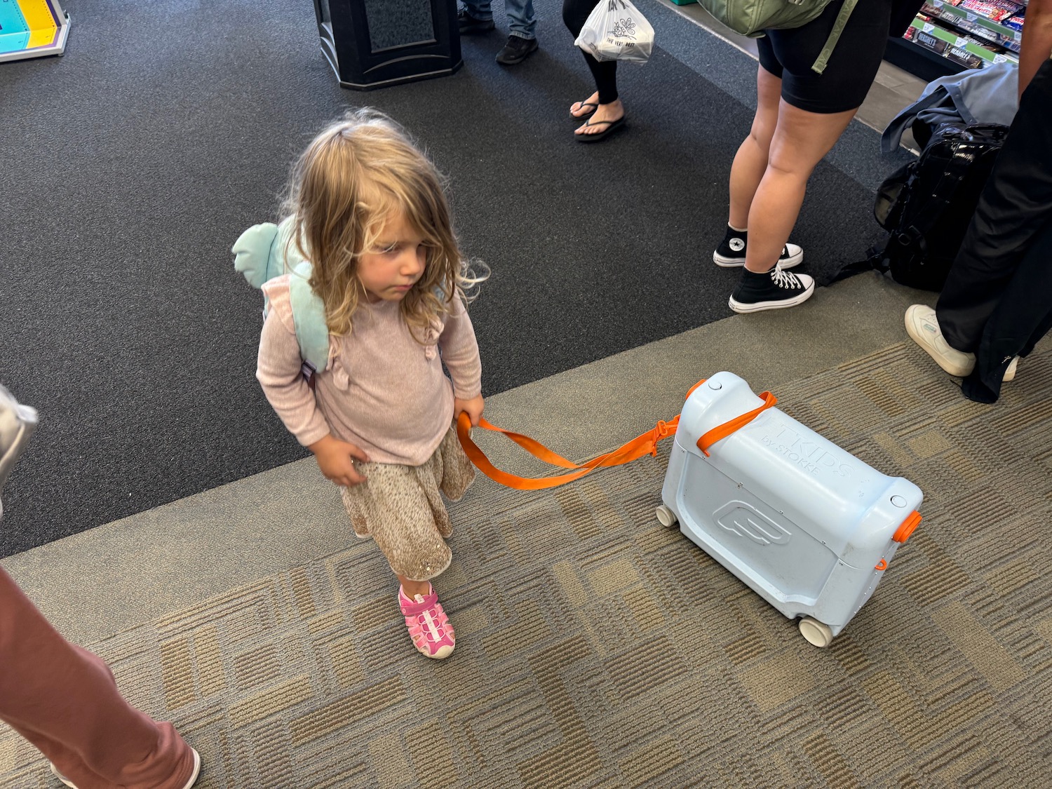 a little girl with a blue suitcase