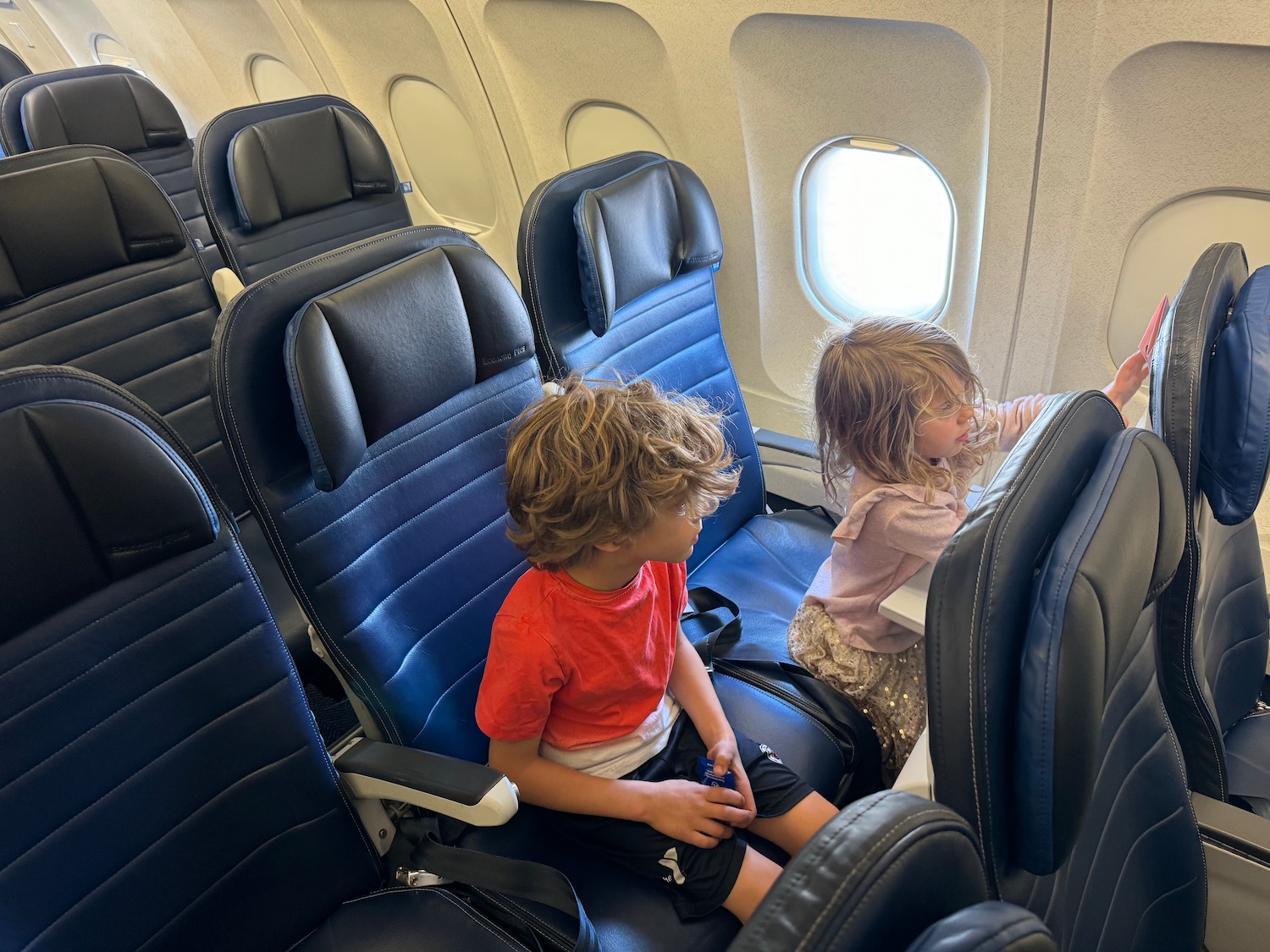 a couple of kids sitting in an airplane