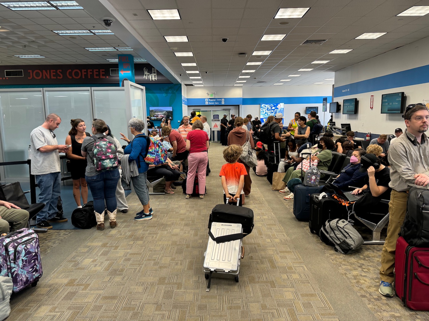 a group of people in a room with luggage