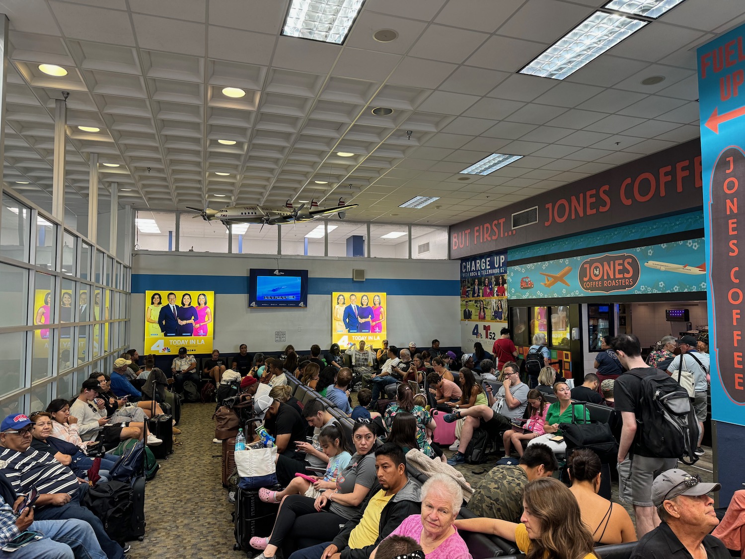 a group of people sitting in a room with a plane above them