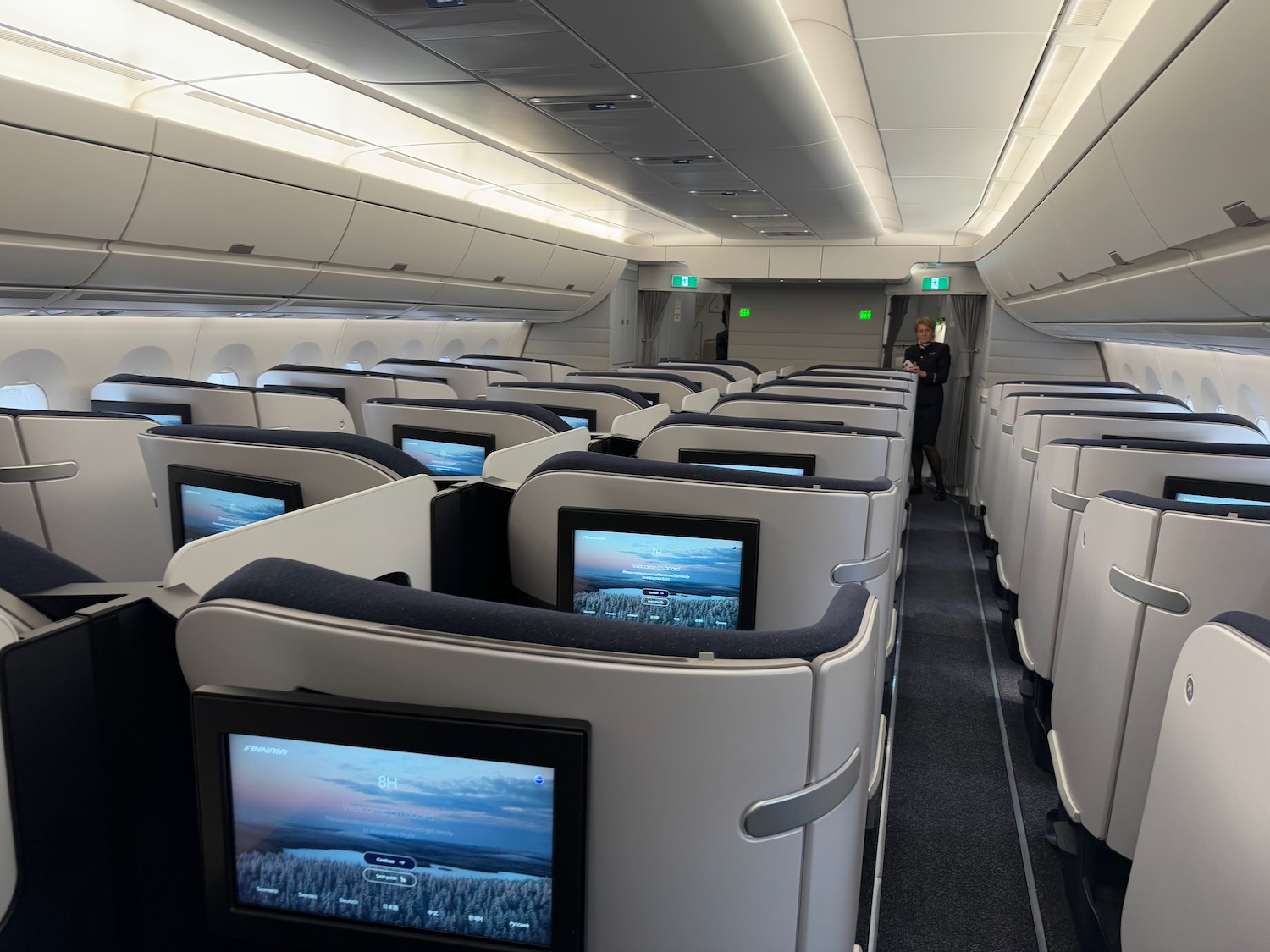 a person standing in a row of seats with monitors on the side