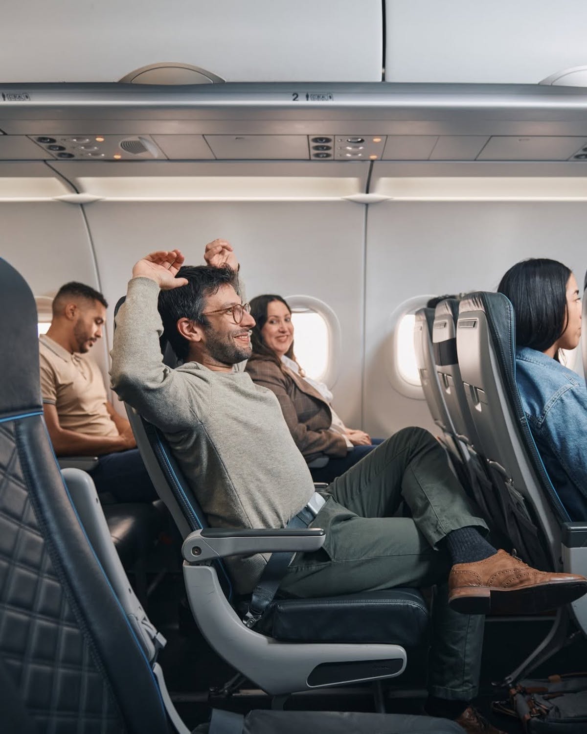 a man sitting in a plane with his hand up