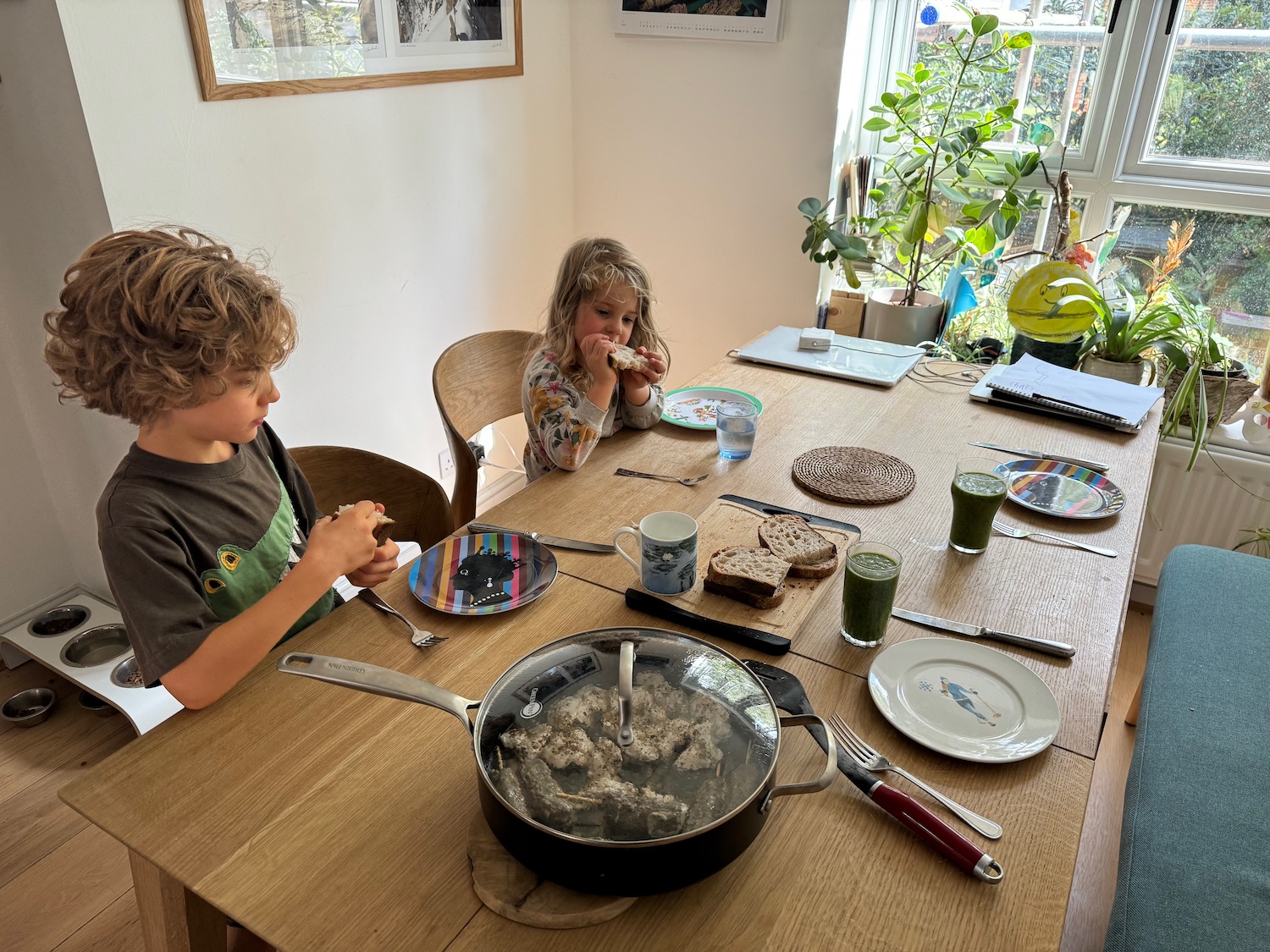 a group of kids sitting at a table eating food