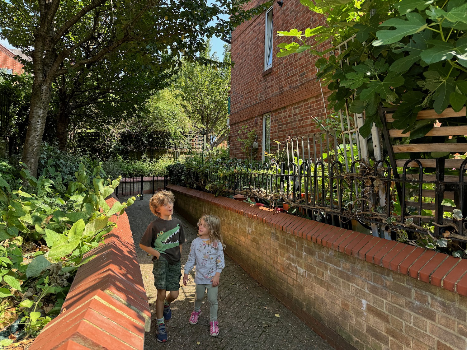 a two children walking on a path in a yard